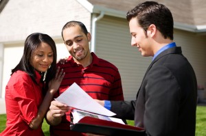 Young couple looking over moving documents with property manager